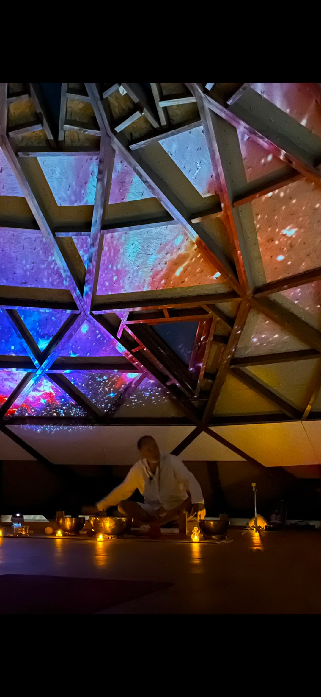Une séance de bols chantants sous des projections lumineuses colorées