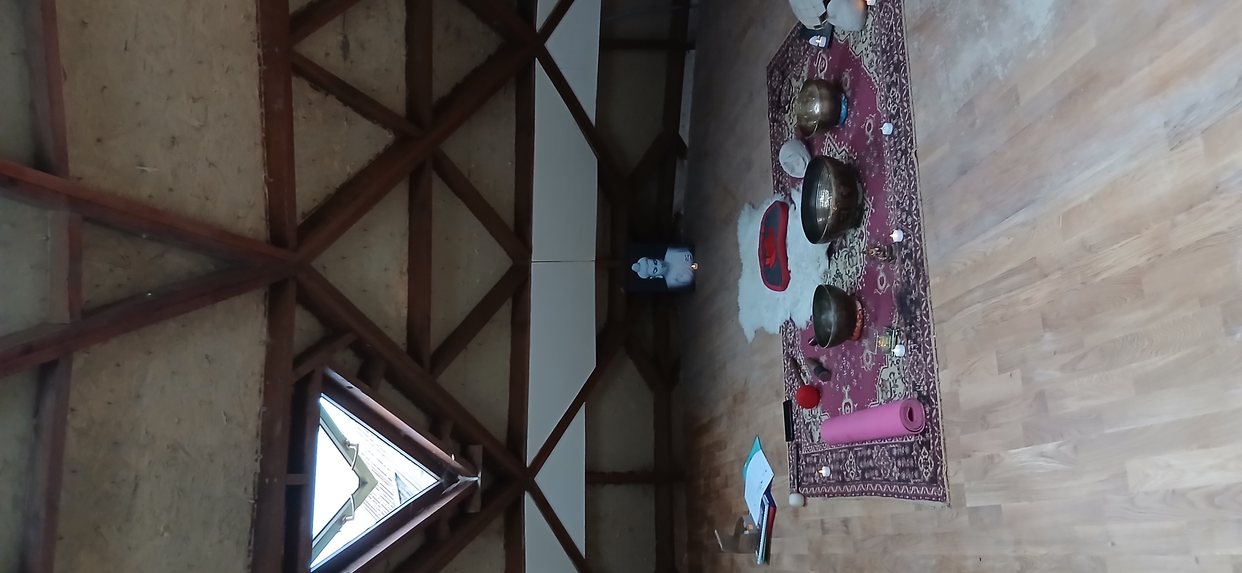 Bols chantants, tapis et coussins disposés sous la charpente du zome